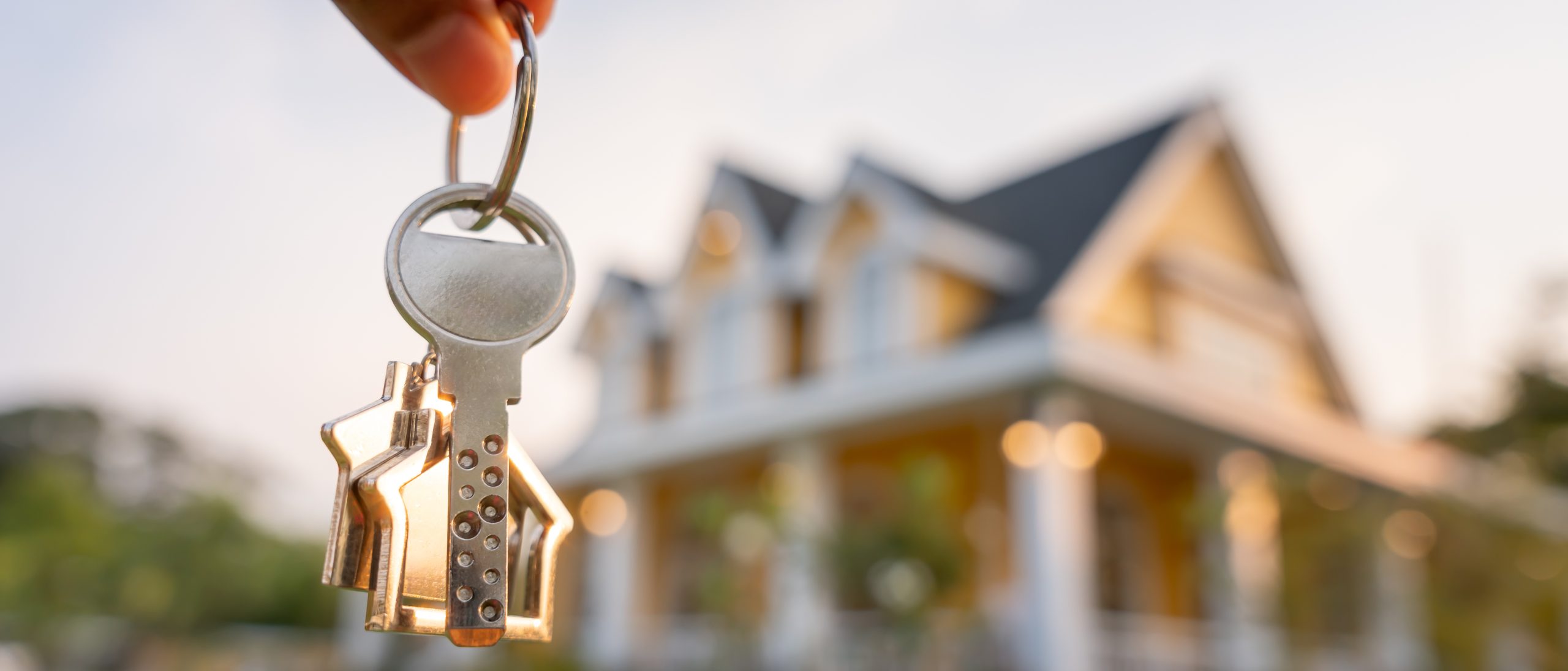 Landlord key for unlocking house is plugged into the door. Second hand house for rent and sale. keychain is blowing in the wind. mortgage for new home, buy, sell, renovate, investment, owner, estate